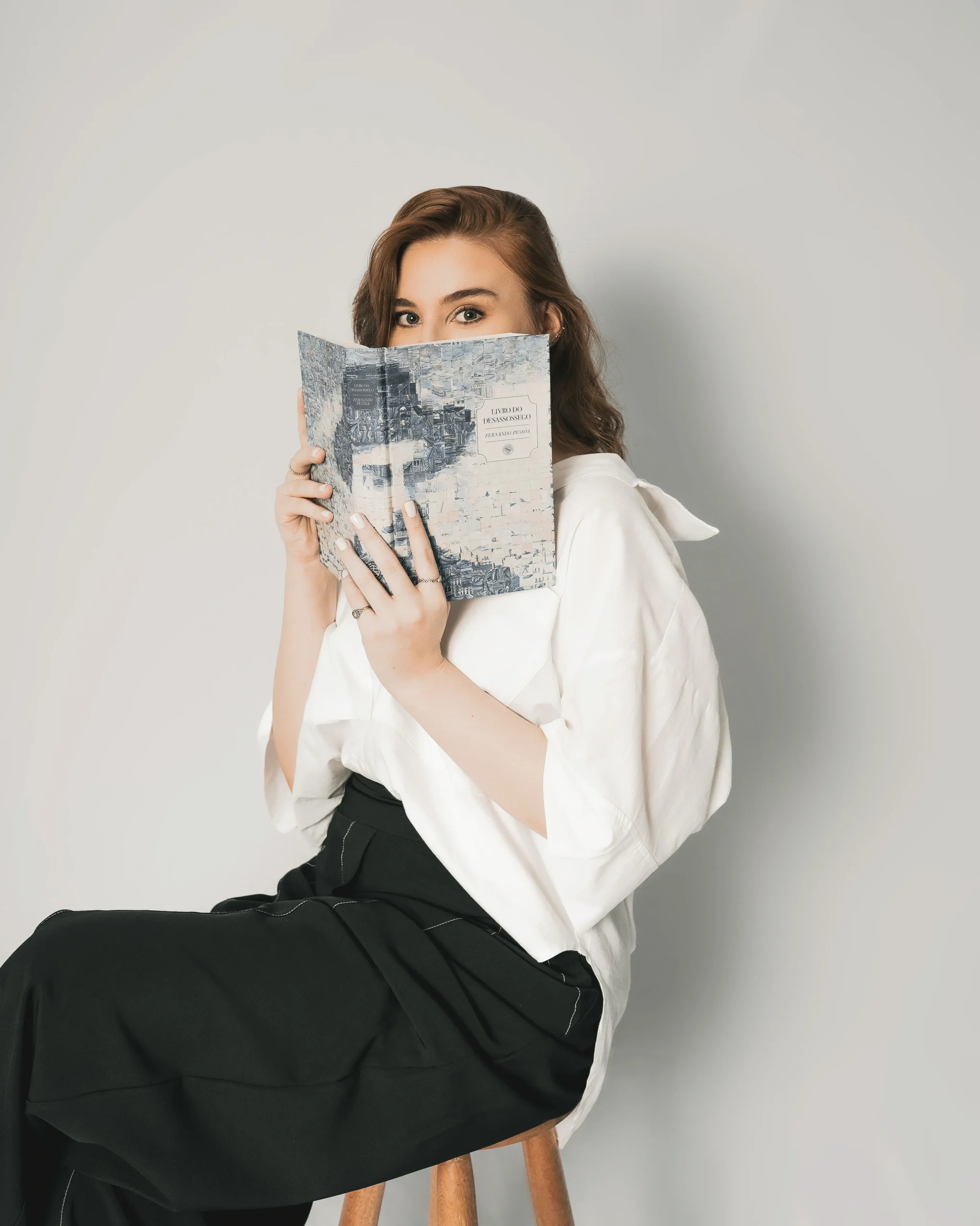 Psicóloga clínica segurando um livro, representando acolhimento e confidencialidade no atendimento