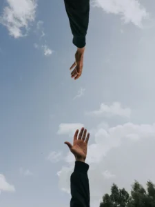 Duas mãos se alcançando, representando apoio emocional e vínculo terapêutico na psicologia clínica